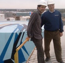 Artist Jaime Gili and Tom Pitts, Northern District Manager for Sherwin-Williams, which donated the paint for the first completed tank