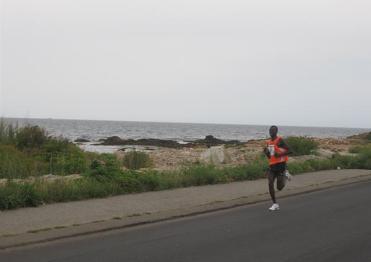 Alan Kiprono of Kenya enjoys the shoreline view of the Run Gloucester! 7-Mile Road Race enroute to winning the inaugural 2010 race.