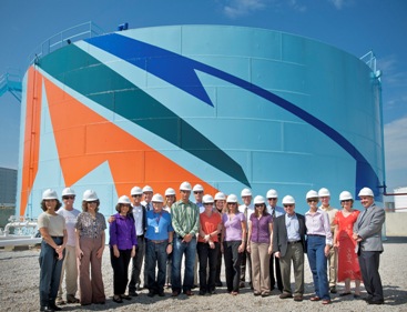 The Board of Directors of Maine Center for Creativity stand proudly in front of the second completed oil storage tank as part of MCC's Art All Around project in Portland Harbor, Maine.